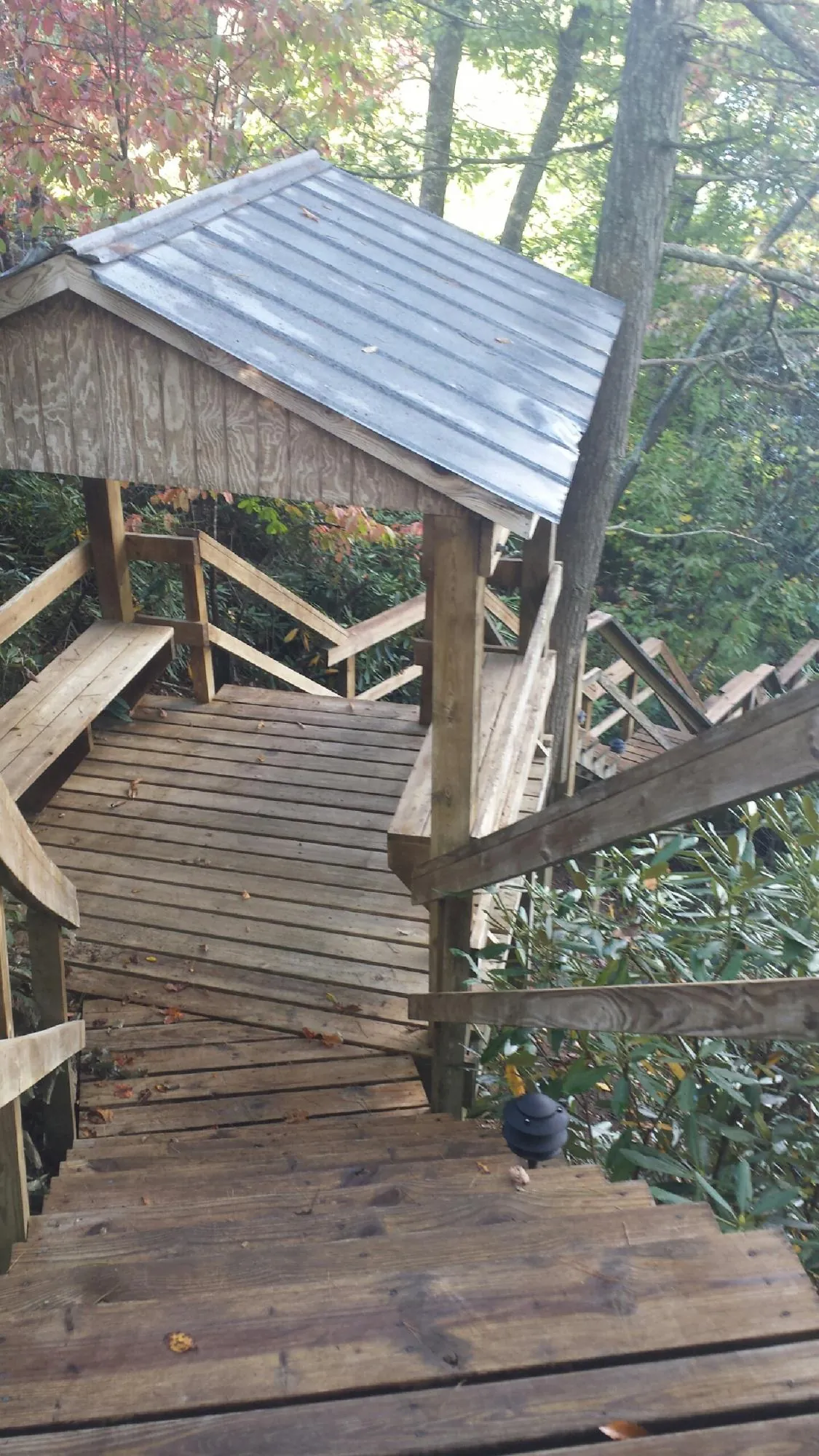 Metal roofed shelter over wooden steps on a wooded walkway — Skylight Repair & Installation work by our crew in Chatham